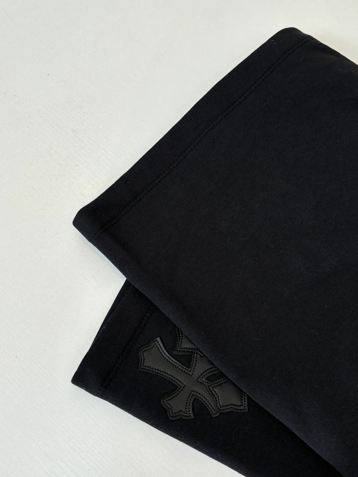 P346 Chrome Hearts*/Chrome Hearts 26SS early spring new patch embroidered shorts The fabric is made of a blended ratio of 80% cotton and 20% polyester. It is woven with a siro spinning process of 32-count base yarn and 10-count veil to form a high-weight terry cloth base of 380g/㎡. The cotton-polyester blended material combines the skin-friendly breathability of cotton and the anti-wrinkle shape retention of polyester. The high-weight fabric gives the trousers excellent stiffness and drape. The core technology is patch embroidery, which is completed with the help of TAJIMA computer embroidery machine. The black special-shaped patch is precisely sewn to the trouser fabric through lock stitches. The embroidery stitch density is even and the edges are neatly hemmed, forming a three-dimensional relief-like visual effect. Size: S/M/L/XL